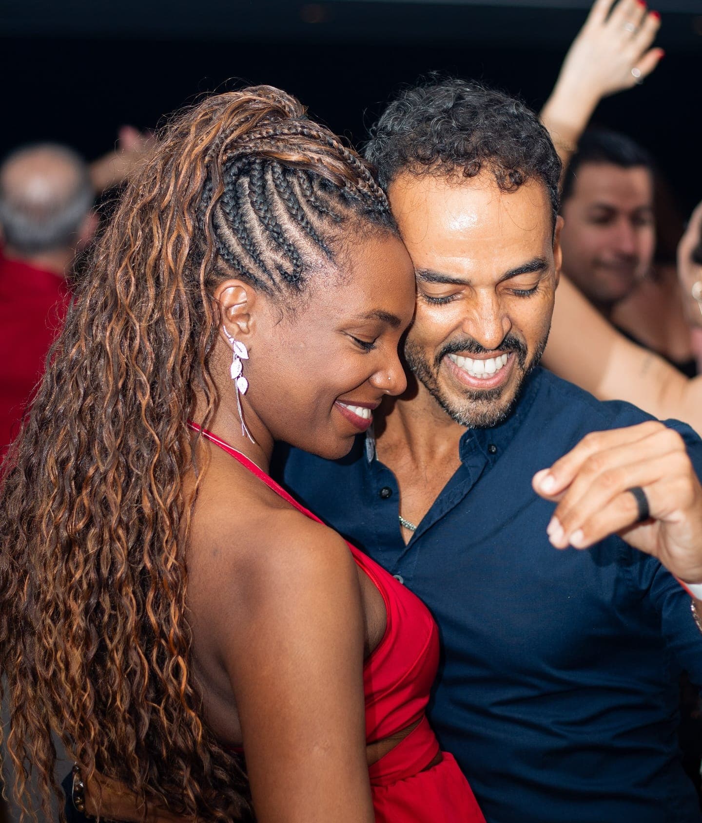Casal dançando junto e rindo em uma aula da NOXI, em Copacabana