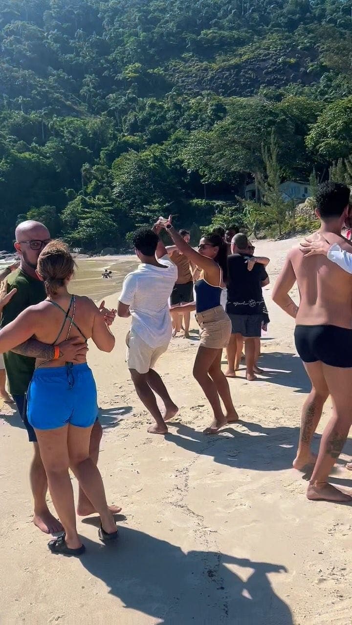 Alunos da NOXI dançando na areia durante a festa de fim de ano da escola